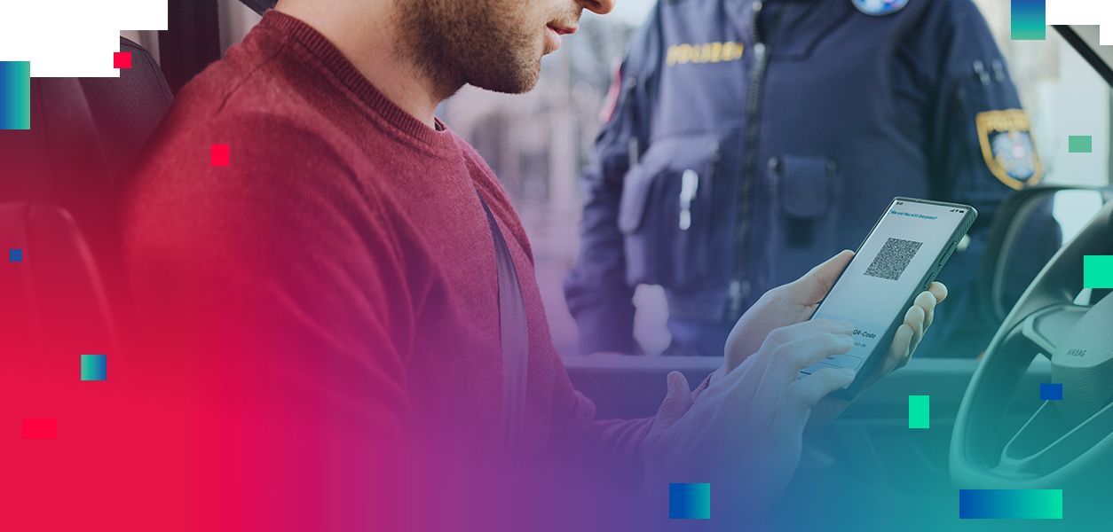 Führerscheinkontrolle mit dem eFührerschein, der am Smartphone hergezeigt werden kann. Mann sitzt im Auto, Polizist steht vor dem Auto und kontrolliert