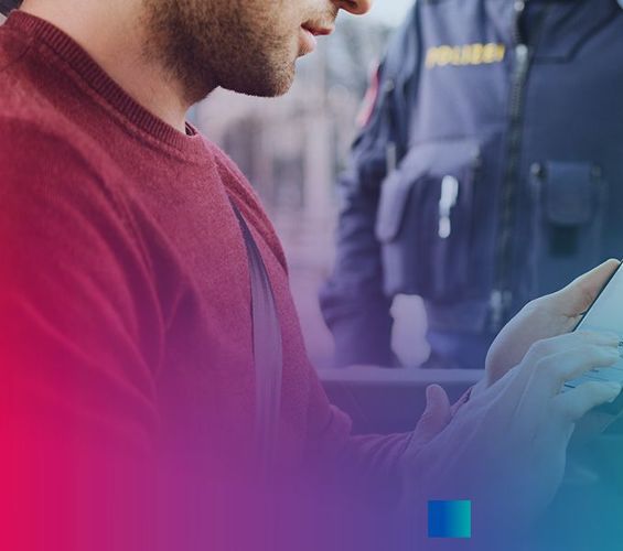 Führerscheinkontrolle mit dem eFührerschein, der am Smartphone hergezeigt werden kann. Mann sitzt im Auto, Polizist steht vor dem Auto und kontrolliert