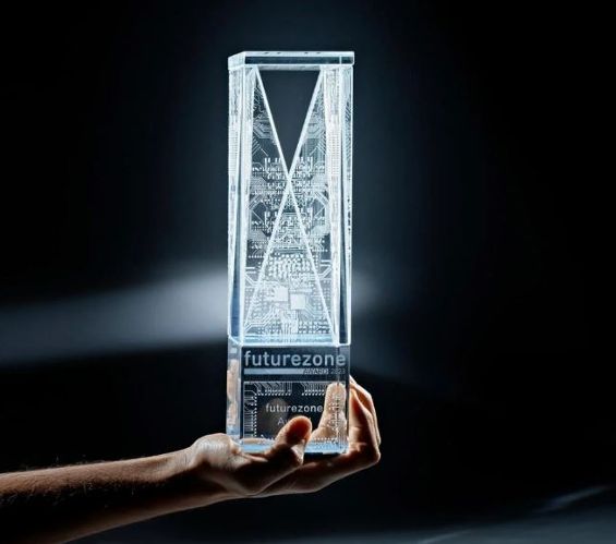 Eine Hand hält den gläsernen futurezone-Award in die Höhe.