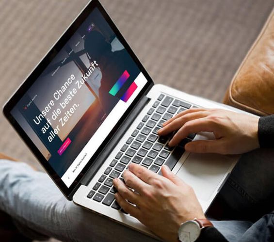 Der Text "Unsere Chance auf die beste Zukunft aller Zeiten" steht auf dem Bildschirm eines Laptops, Hände liegen auf der Tastatur.
