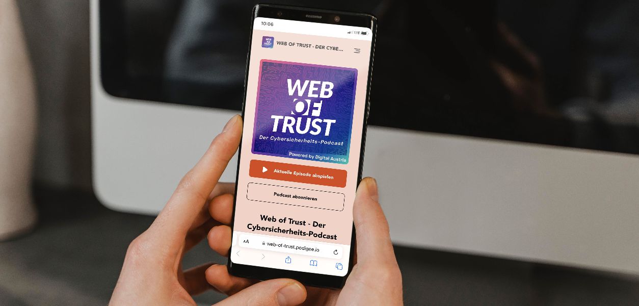 Person hält ein Smartphone das den Cybersicherheits-Podcast zeigt